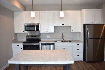 Modern kitchens with islands, white marble-look countertops and stainless steel appliances